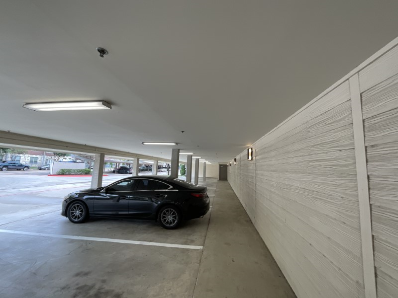 Parking lot light fixtures illuminated during daylight